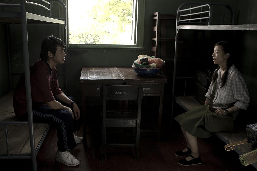 一男一女分别坐在宿舍两侧交谈