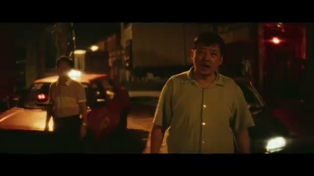 男子站在夜间公路的车辆之间