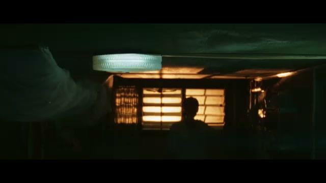 昏暗房间里一名男子背对亮窗站立