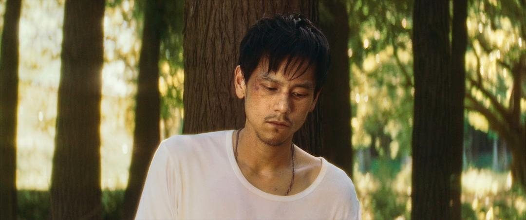 白衣男子在树林前闭眼低头
