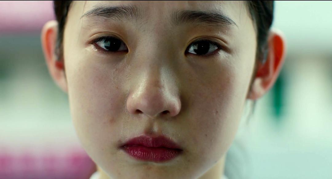 剃短头发的少女眼含泪水望向一侧