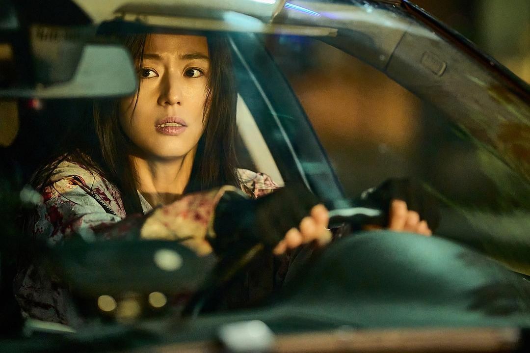 衣服沾血的女子握着方向盘望向车窗外