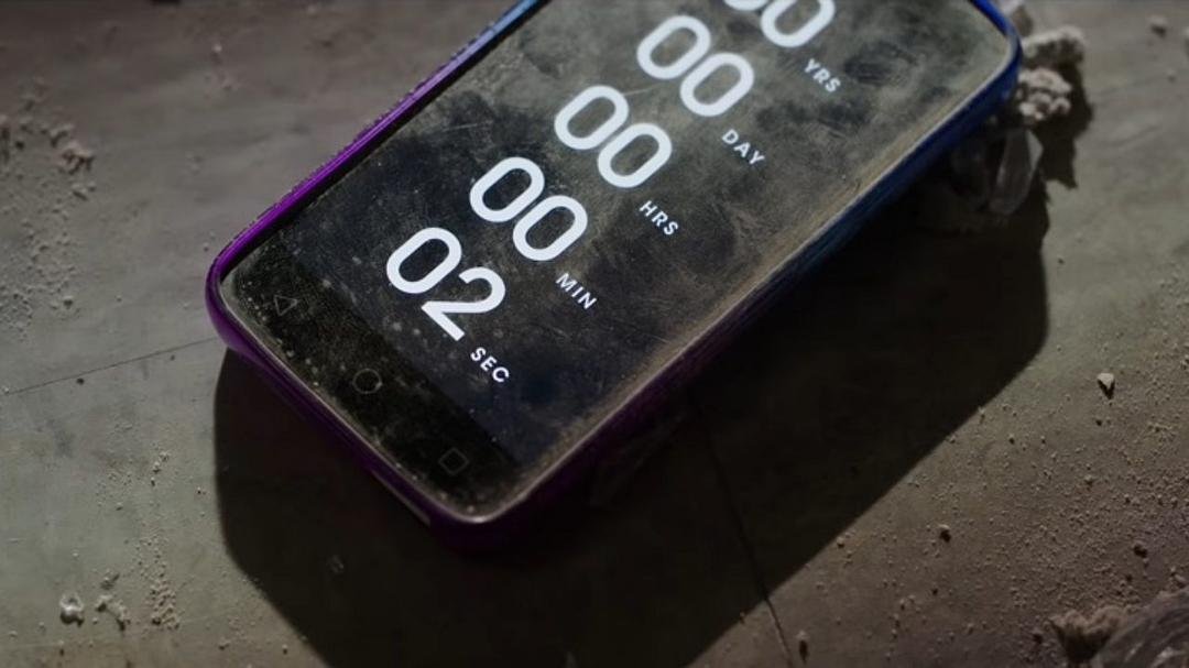 落在灰尘地面上的手机显示只剩两秒的倒计时