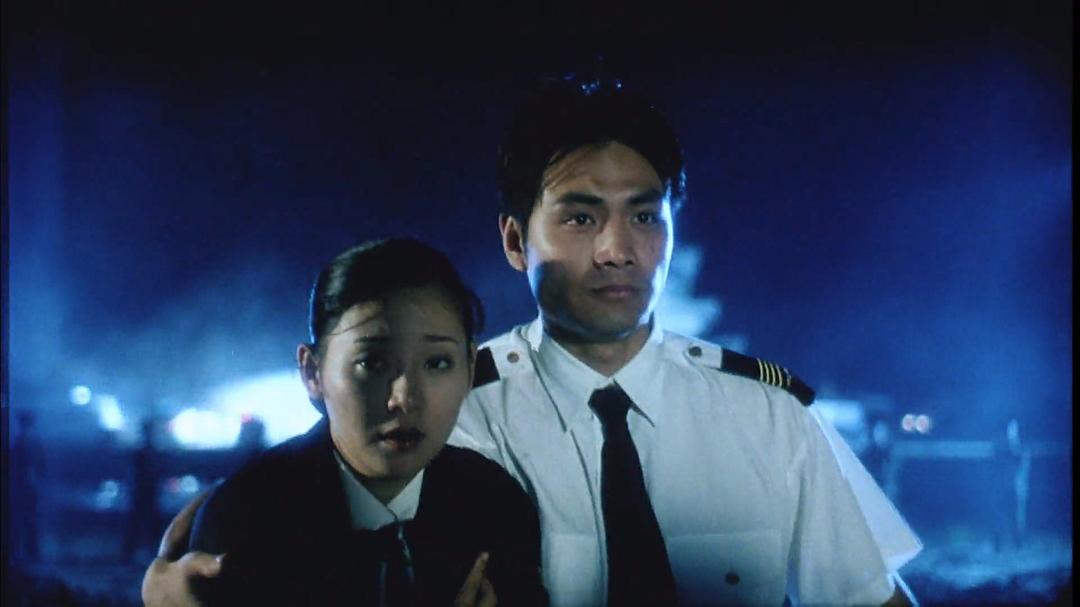 穿飞行员制服的男子与制服女子站在夜间救援现场