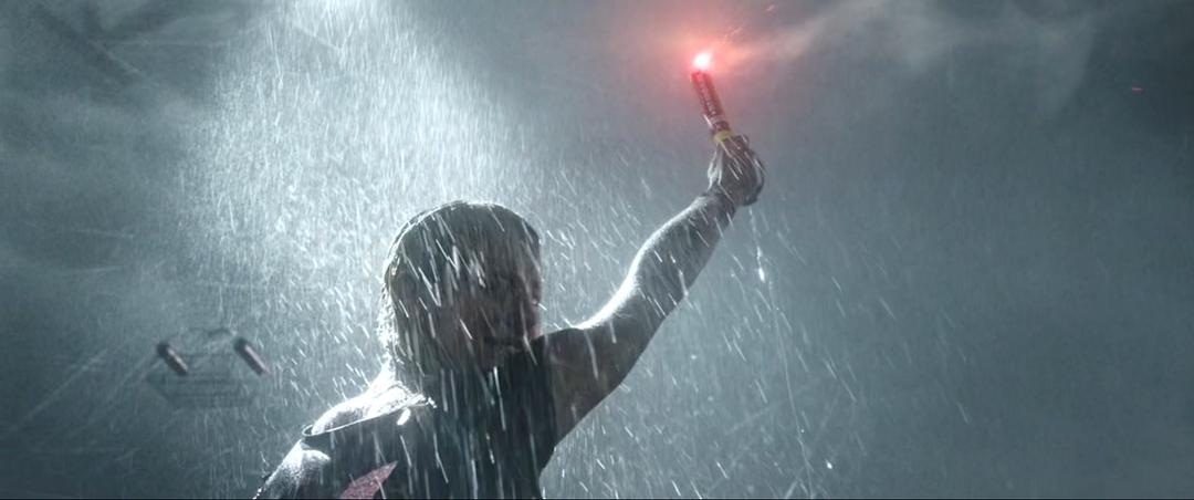 暴雨中的人举起发出红光的信号棒