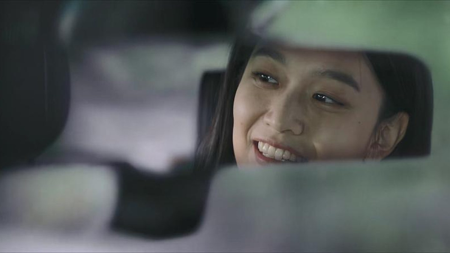 年轻女子从汽车后视镜里看向身边的人