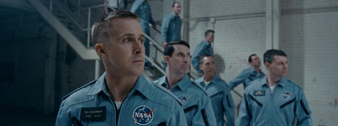 多名穿有 NASA 标志蓝色飞行服的人站在室内