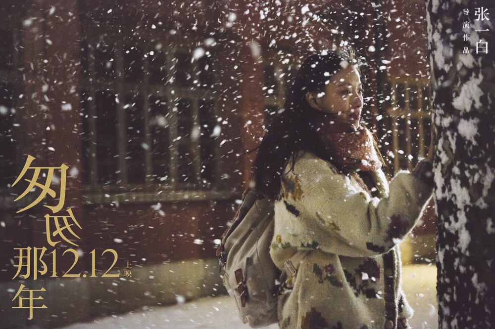 女生在飘雪的夜里蹲地掩面