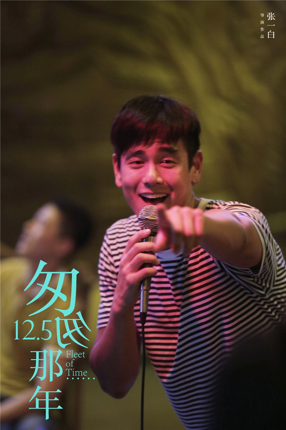 男子拿着麦克风在舞台上唱歌