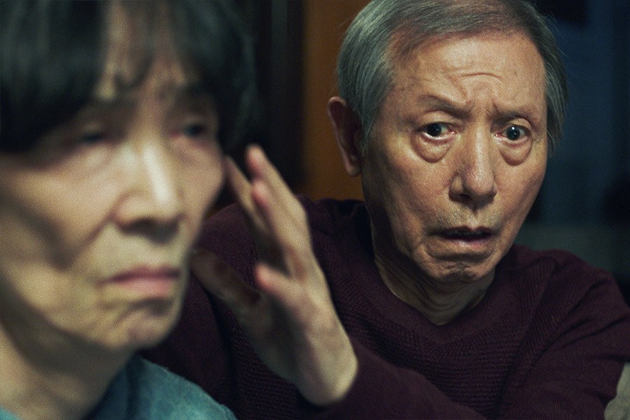 白发男子伸手触碰身旁老妇的脸