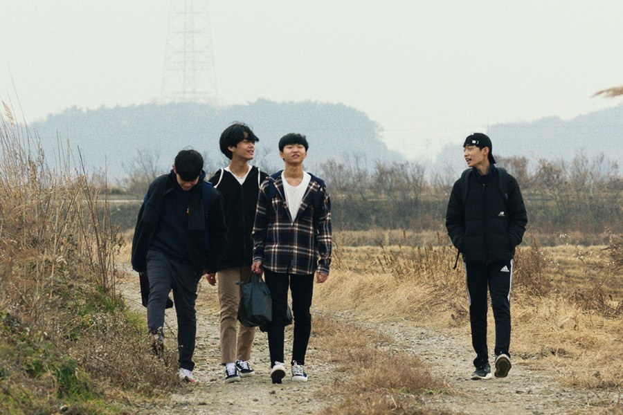 四名少年沿乡间土路走来