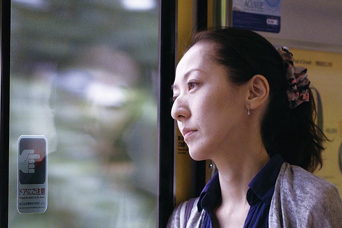 束发女子坐在车窗旁望向一侧