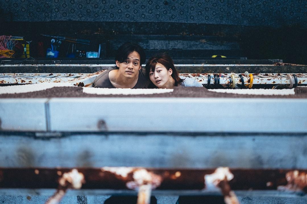 一男一女从水族箱下方探出头看向前方