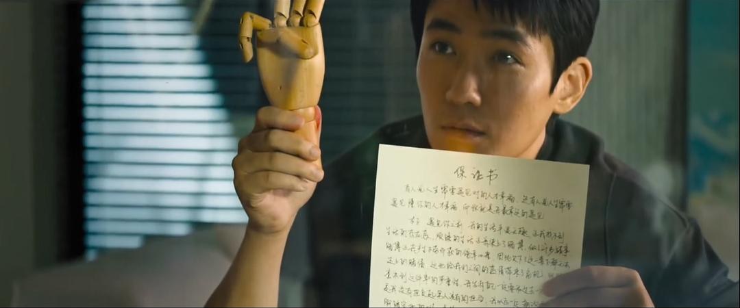 何非举着木偶和手写材料说明自己讲述的往事