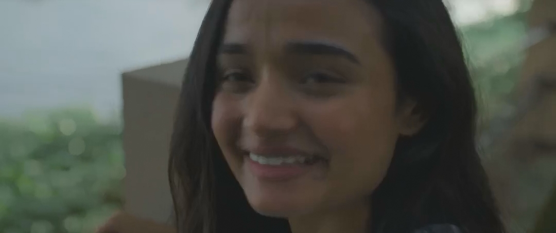 长发年轻女子在窗边含泪微笑