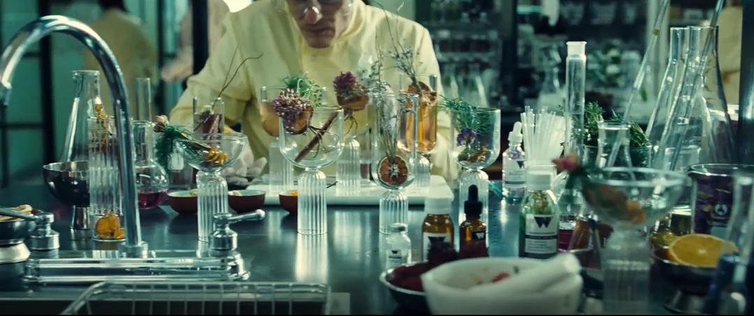 实验人员在摆满玻璃器皿和植物样本的工作台前操作