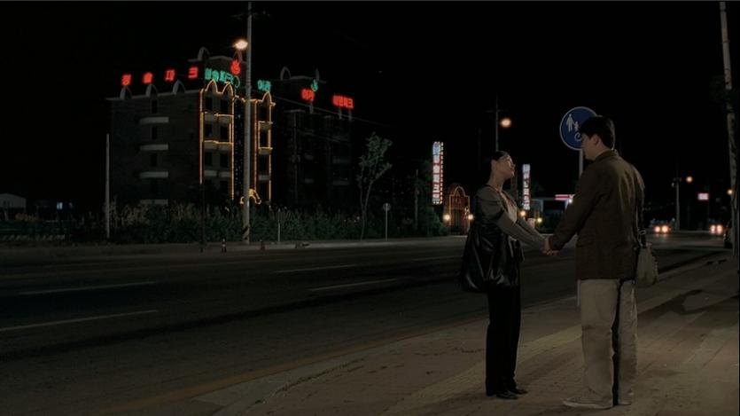 夜色中，善英与庆洙站在街边保持距离交谈