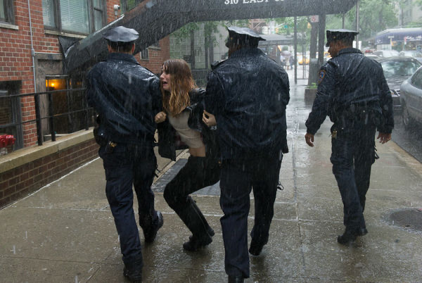 雨中一名女子被三名警察带走
