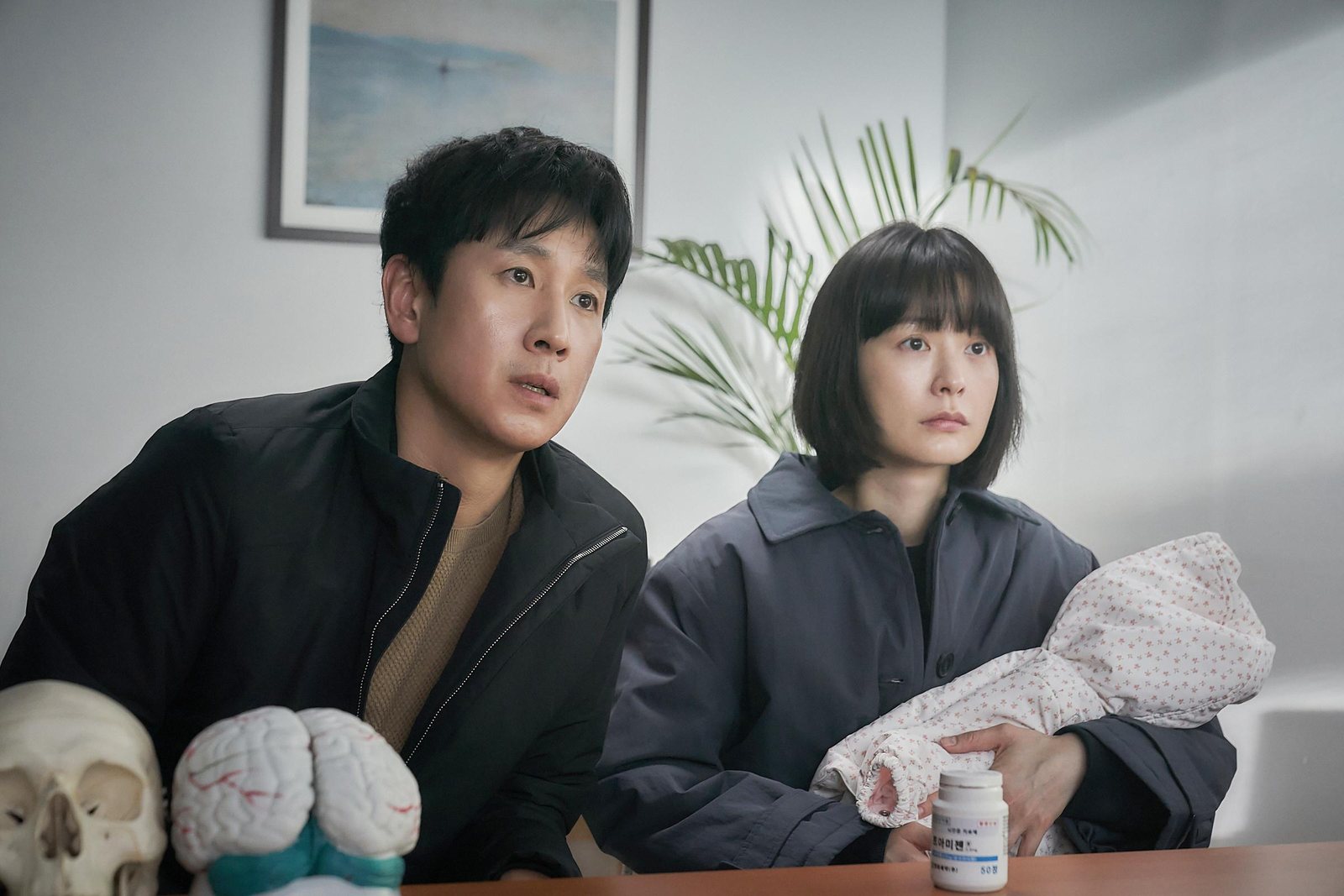 夫妻抱着襁褓中的婴儿坐在诊室里