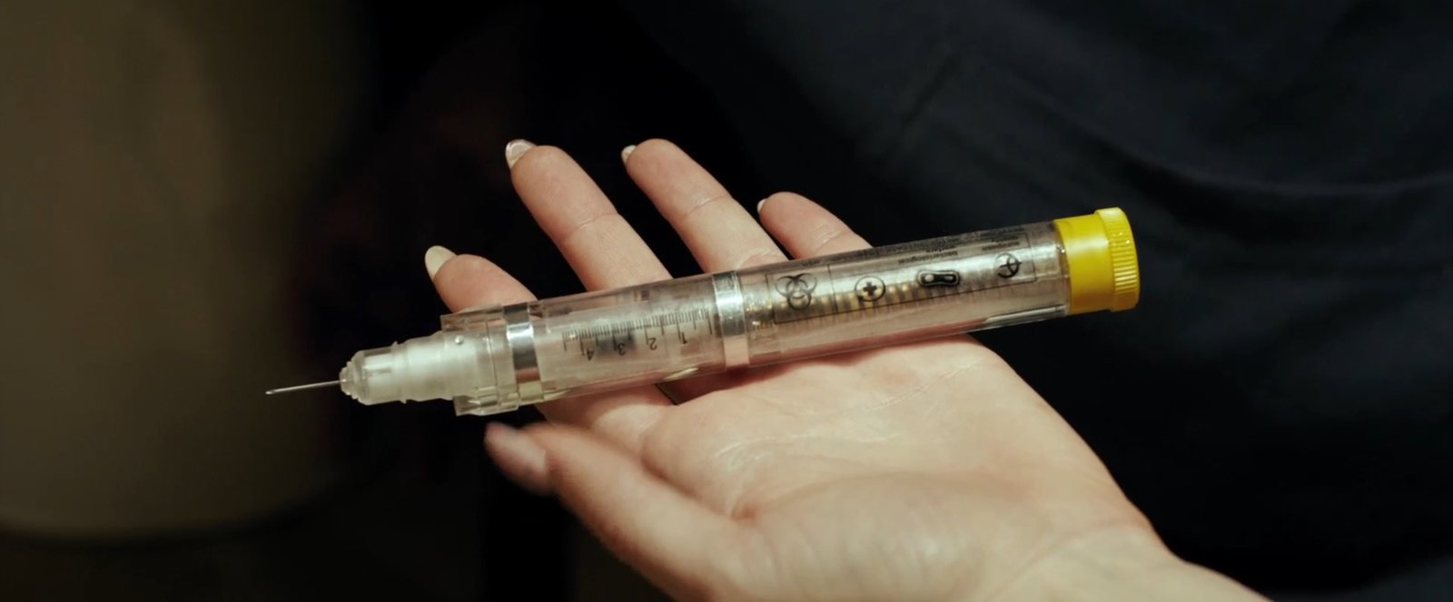 一支装有药液的注射器放在手掌上