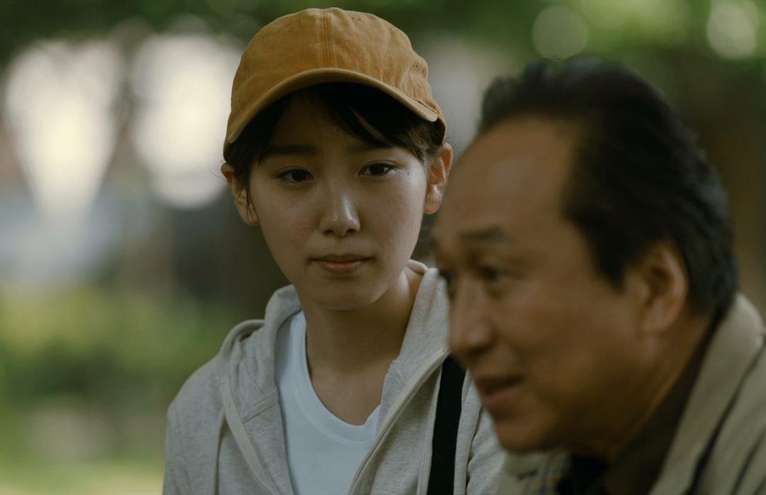 戴帽的年轻女子坐在一名年长男子身旁