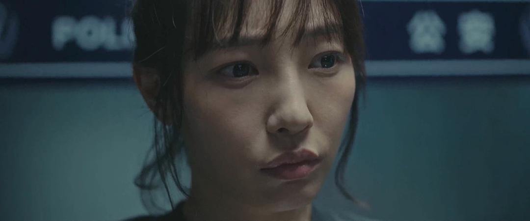 一名女子站在写有警察字样的背景前