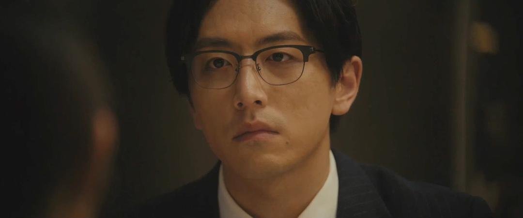 一名戴眼镜的男子在室内看向前方