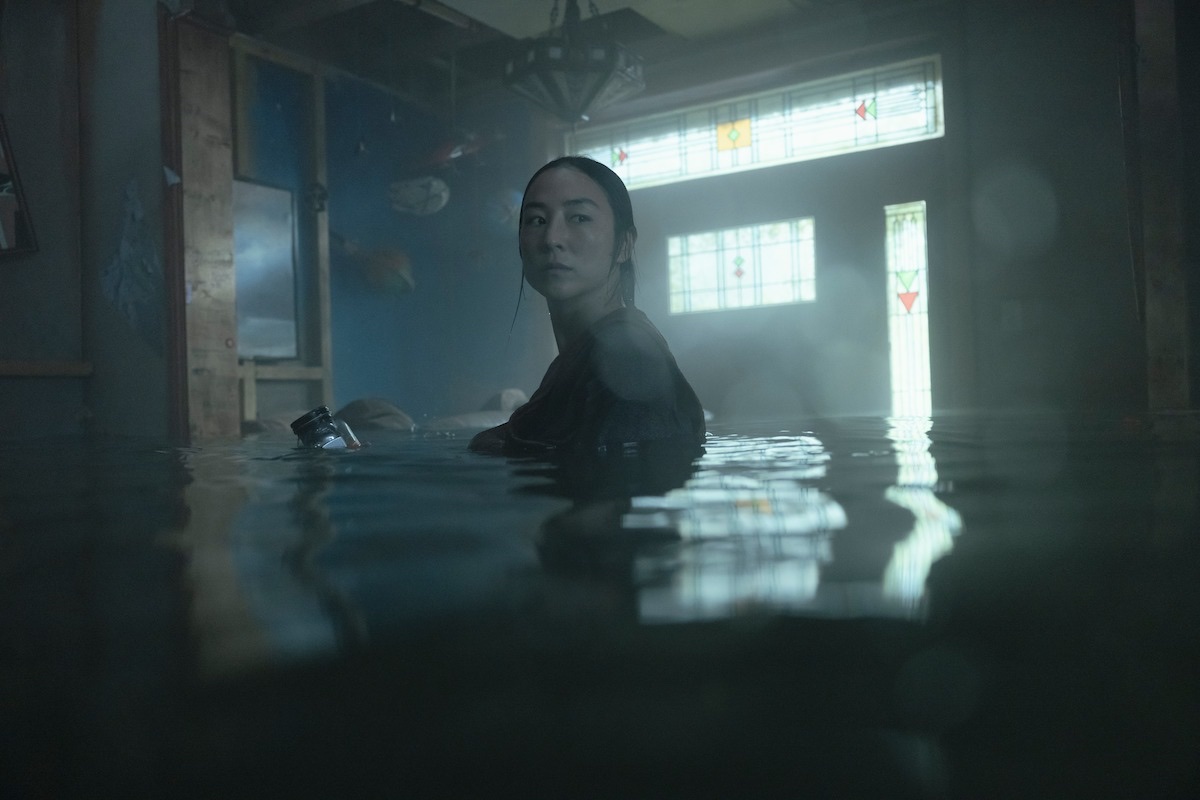 一名女子站在水淹至胸口附近的室内