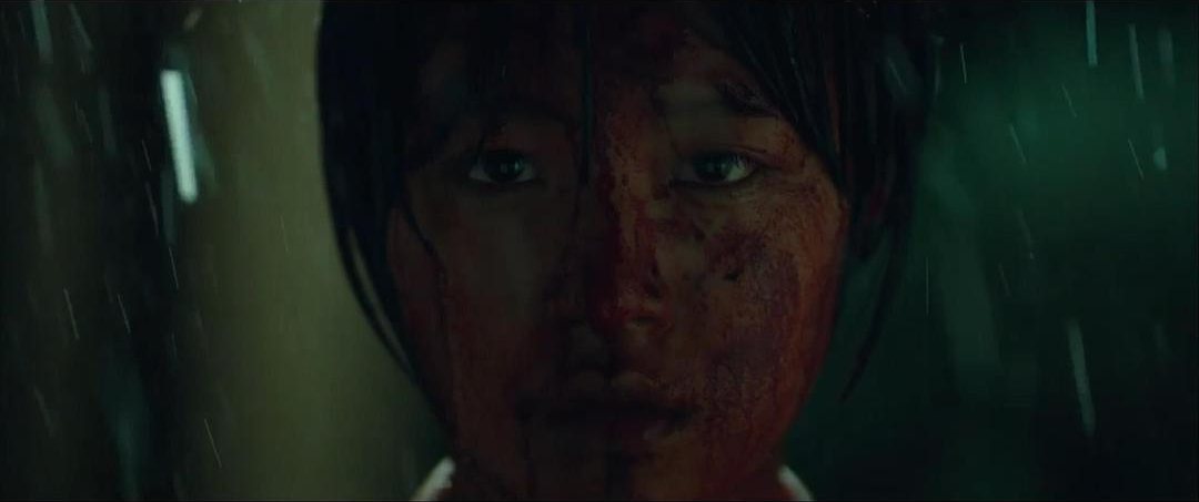 一名面部带血的短发女子在雨中望向前方