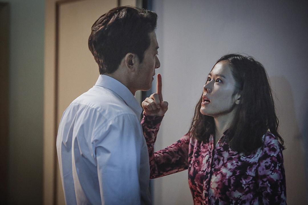 一名穿花衣的女子抬手指向一名白衬衫男子