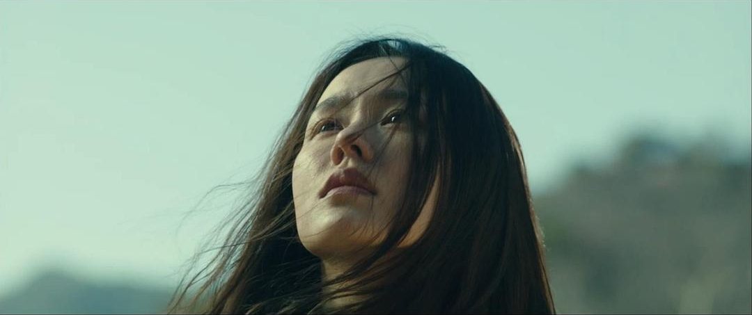 一名头发凌乱的女子仰头望向天空