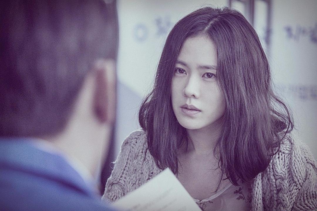 一名长发女子手持文件面对画面外的人