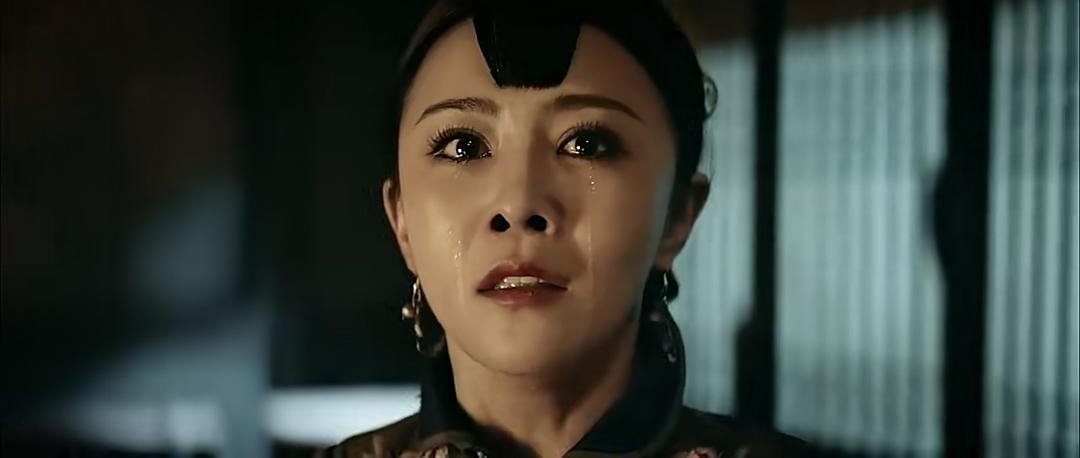 身穿绣花衣服的女子含泪望向前方