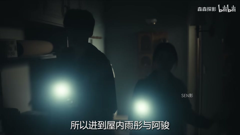 一男一女站在昏暗房间内，各自打开手机照明