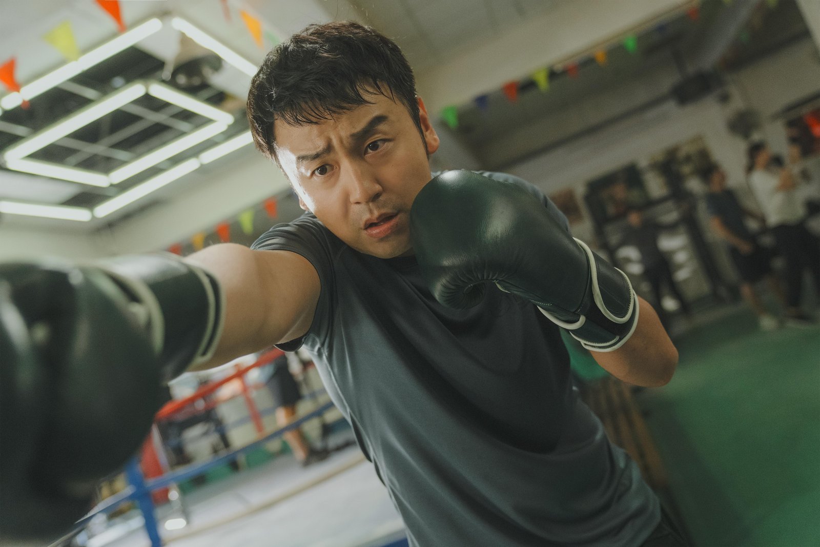 昊坤戴着拳套在拳馆练习出拳