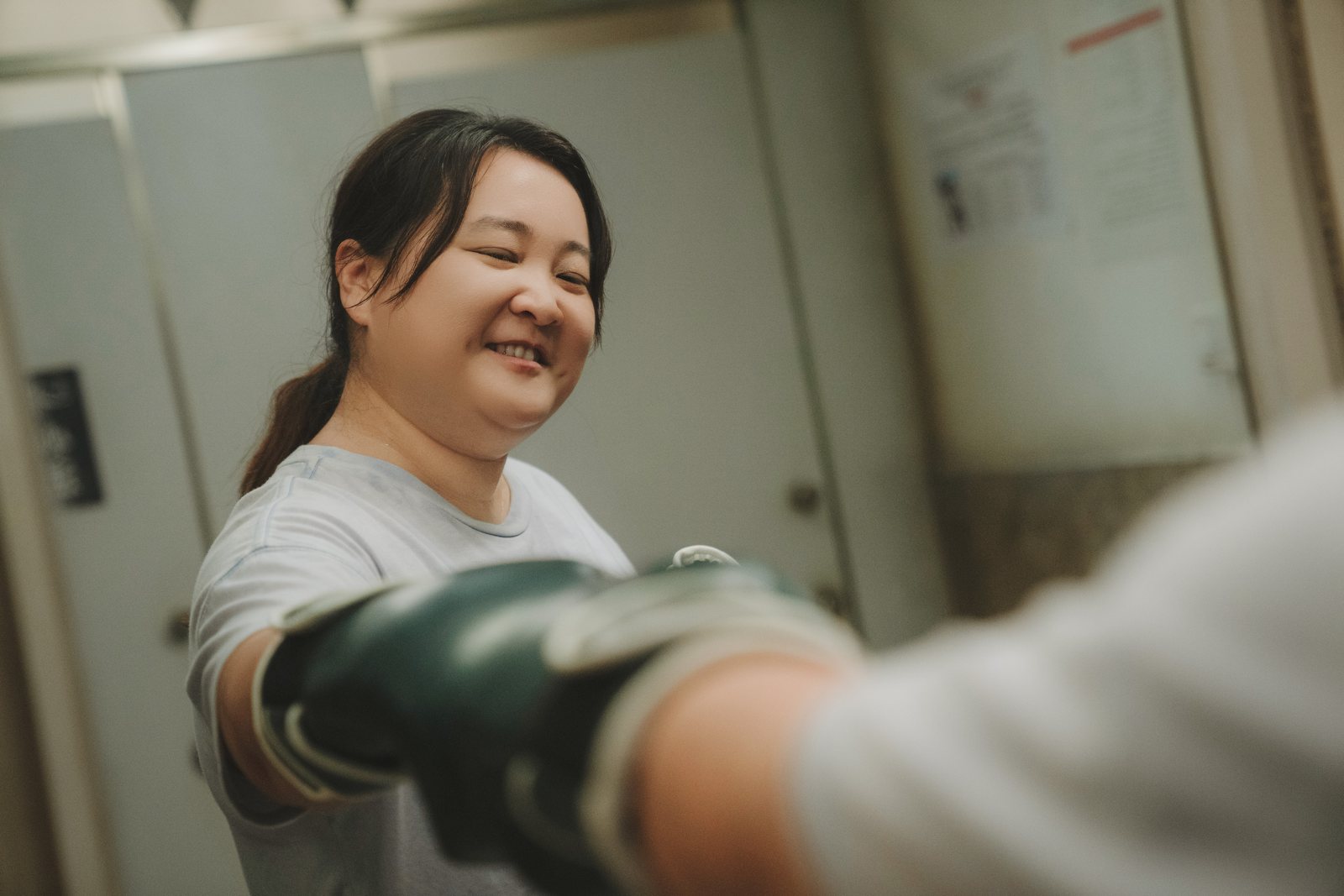 戴着拳套的乐莹在拳馆与人碰拳